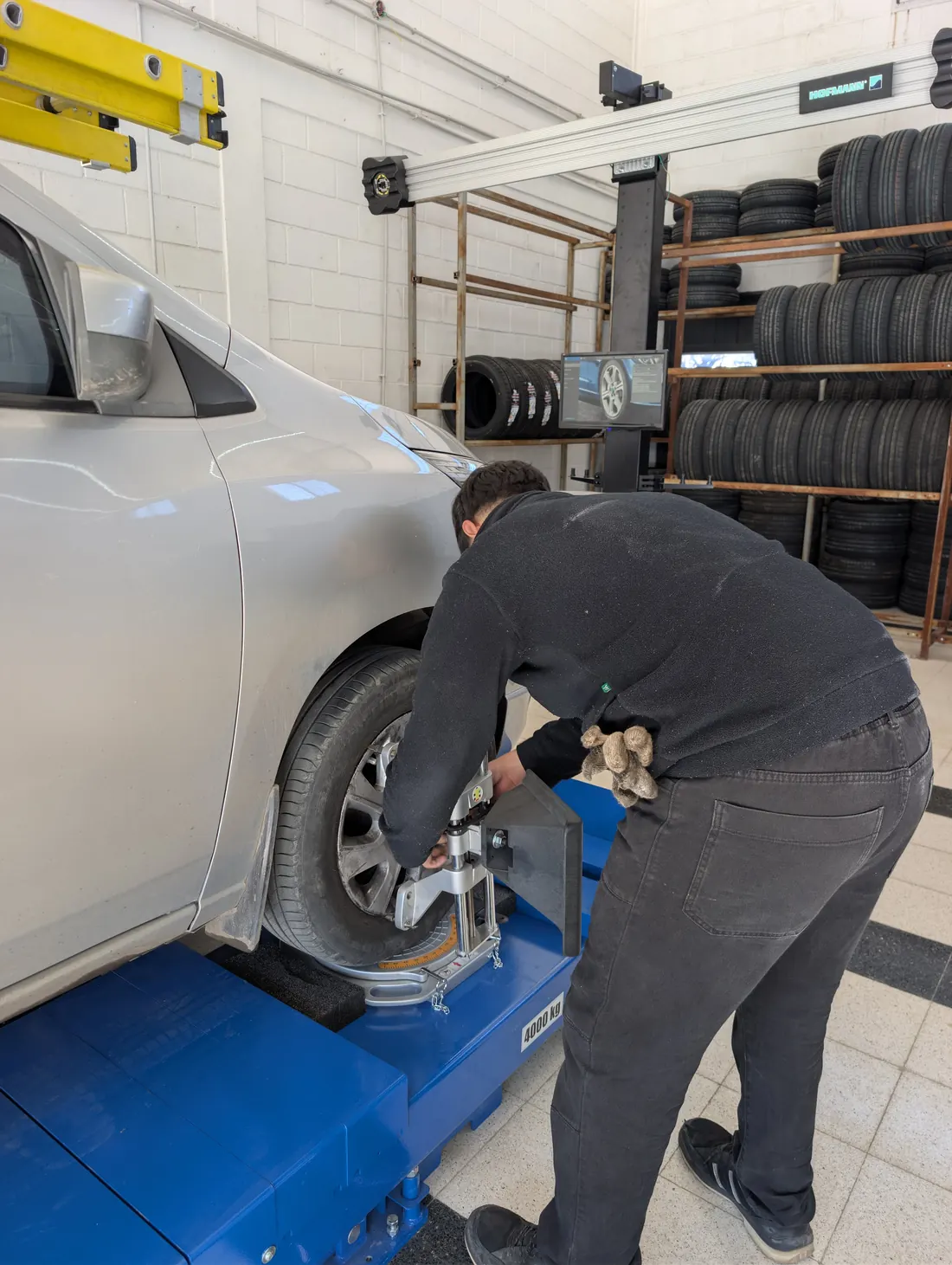 Técnico colocando el target de alineación 3D en la rueda de un auto