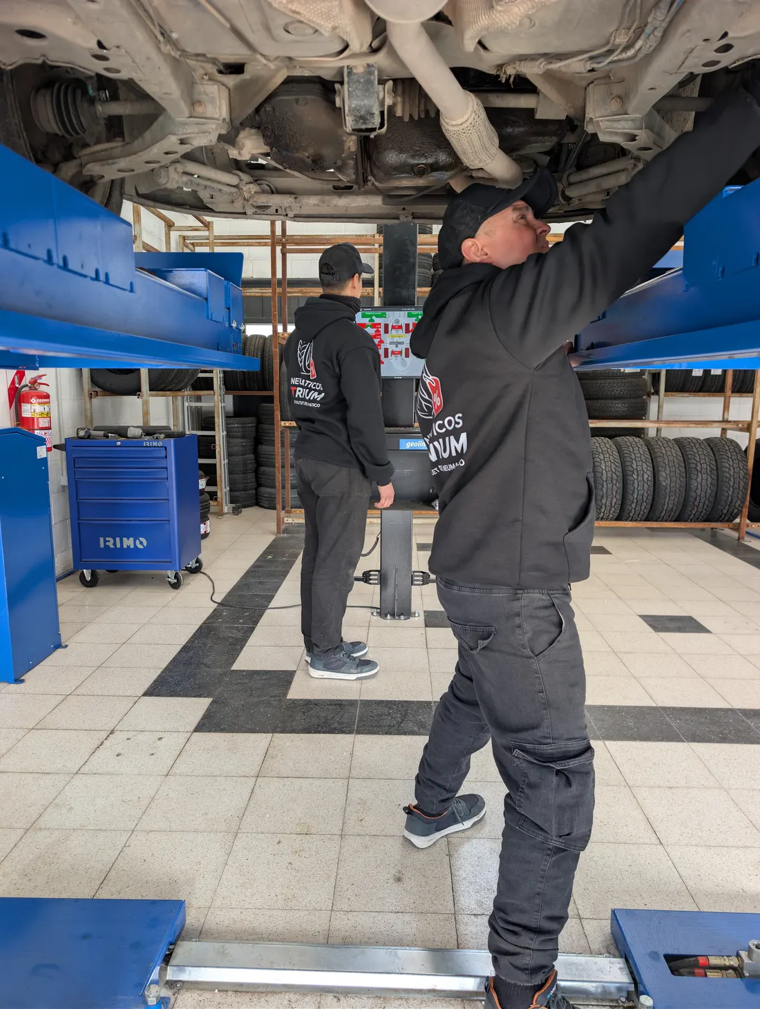 Técnicos alineando un auto en el elevador del taller de Trivium en Córdoba